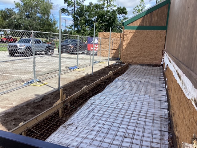 Rear view of restaurant in Lakewood, FL with fencing in place as VMC Facilities begins a 328 sq. ft. cooler addition project.