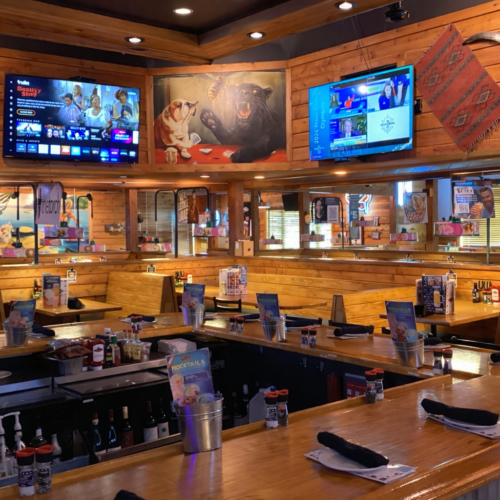 Interior of Texas Roadhouse in Gainesville, GA following renovation, featuring new wooden booths, updated bar seating, lighting adjustments, and refreshed dining layout.
