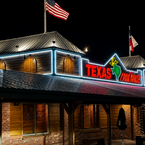 Nighttime exterior view of completed restaurant renovation in Palm Beach, Florida featuring updated architectural finishes, illuminated signage, enhanced exterior lighting, and refreshed storefront appearance.